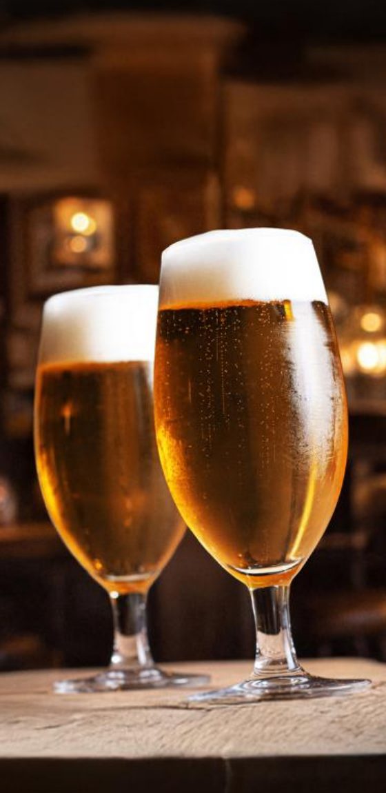 To Rastal Bergen ølglass med pils på et bardisk